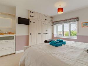 een slaapkamer met een groot bed met blauwe kussens erop bij 2 Bed in Cromer DAIN8 in Northrepps