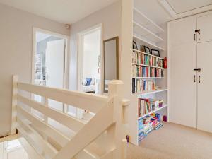 een witte trap in een kamer met boekenplanken bij 2 Bed in Cromer DAIN8 in Northrepps