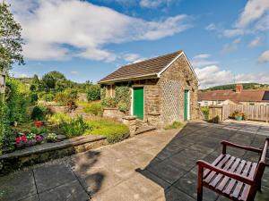 a stone building with a bench in a garden at 2 Bed in Sawmills PK934 in Whatstandwell