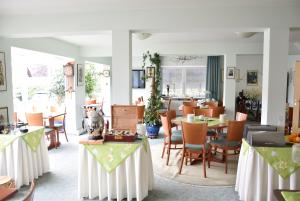 jadalnia ze stołami i krzesłami oraz pokój ze stołami i fotelem w obiekcie Niebuhrs Hotel w mieście Friedrichsdorf
