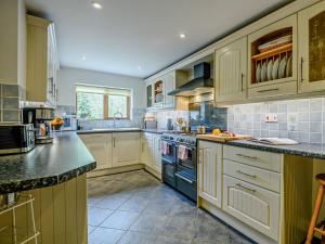 a large kitchen with white cabinets and a blue oven at 4 Bed in Sway NFL94 in Sway