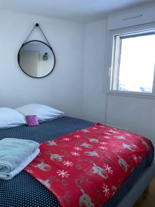 a bedroom with a bed with a red blanket and a mirror at Magnifique T3 au Pla D Adet (Saint Lary)grand confort entièrement refait à neuf avec une vue exceptionnelle sur la vallée in Saint-Lary-Soulan