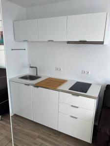 eine weiße Küche mit Spüle und Herd in der Unterkunft 26 Puerto del Carmen Palm tree in Puerto del Carmen + 1 Foto