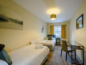 a hotel room with two beds and a desk at 2 Bed in Sanquhar 89402 in Sanquhar
