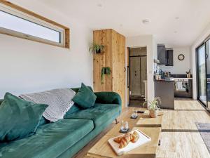 a living room with a green couch and a table at 1 Bed in Worcestershire 89032 in Abberley