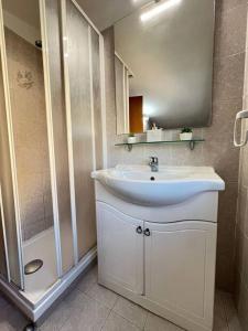a bathroom with a white sink and a shower at Tramonti In Santa Marinella in Santa Marinella