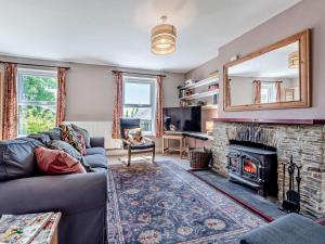 a living room with a couch and a fireplace at 3 Bed in Brechfa 92116 in Rhyd-cymmerau