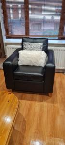 a black leather couch sitting in a living room at 2 bed cosy apartment in heart of Mullingar. in Mullingar