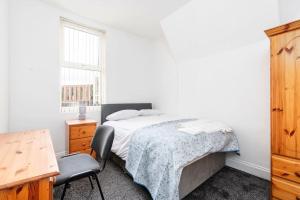 1 dormitorio con cama, escritorio y silla en Large 5 bedroom town house in Edgbaston, 2 kitchens en Birmingham