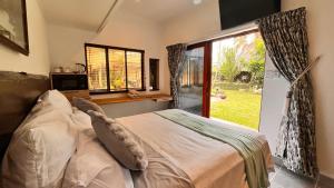 ein Schlafzimmer mit einem Bett und einem großen Fenster in der Unterkunft The Wood House in Empangeni