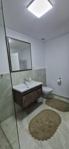 a bathroom with a sink and a mirror and a toilet at Near to airport 2 in Sînnicoară