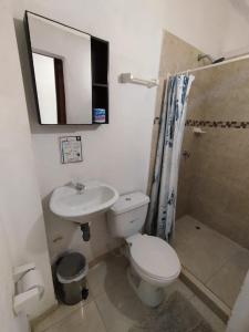 La salle de bains est pourvue de toilettes, d'un lavabo et d'un miroir. dans l'établissement Sierraventura Hostel, à Taganga