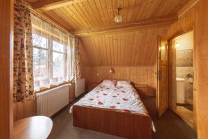 1 dormitorio con 1 cama en una habitación con ventana en Kiry 9 - pokoje i apartamenty, en Kościelisko