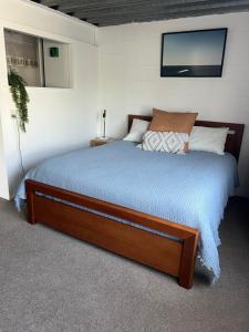 a bedroom with a bed with a tv on the wall at Downtown B&B in Mount Maunganui