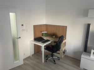 ein Büro mit einem Computertisch und einem Stuhl in der Unterkunft Moderní byt v Brně u BRuNA in Slatina