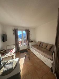 a living room with a couch and a window at Le shuss 4 la foux d'allos in La Foux