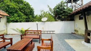 patio z drewnianymi ławkami i białym płotem w obiekcie Pousada Cunhantã w mieście Alter do Chao