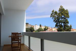 a chair on a balcony with a view of a tree at Mel Apartment in Funchal