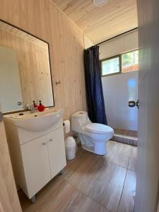 een badkamer met een wit toilet en een wastafel bij Cabaña gam.nav in Vichuquén