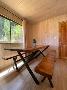a large wooden table in a room with a bench at Cabaña gam.nav in Vichuquén +6 photos