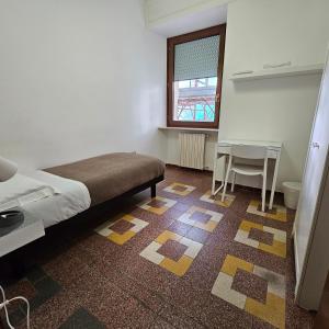 a bedroom with a bed and a table and a window at Alloggio in Centro Città con Parcheggio Privato e WIFI in Potenza