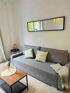 - un salon avec un canapé gris et une table dans l'établissement Maxipau, à Tolède
