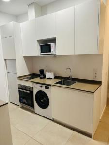 eine Küche mit einer Waschmaschine und einer Mikrowelle in der Unterkunft Maxipau in Toledo
