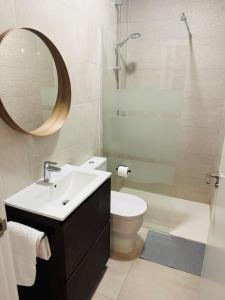 ein Badezimmer mit einem Waschbecken, einem WC und einem Spiegel in der Unterkunft Maxipau in Toledo