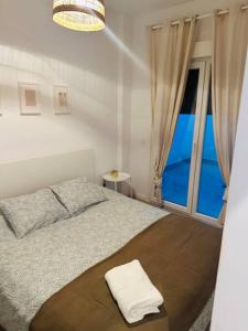 1 dormitorio con 1 cama y ventana grande en Maxipau en Toledo