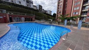 a large blue swimming pool in front of some buildings at Pearl 23 in Pereira