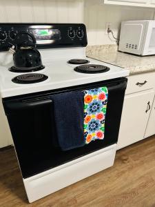 a black and white stove with a towel on the oven at Beautiful 2BR apt in Beach community, Close to Train and hwys! ONLY 1 hr to NYC! in Norwalk