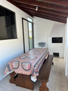 comedor con mesa y banco en Casa no centro de Garopaba, en Garopaba