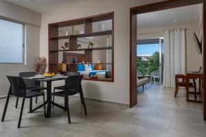a dining room with a table and a bedroom at Blue Veleta in Tulum