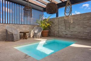 a swimming pool in a patio with chairs and a table at Blue Veleta in Tulum +39 photos