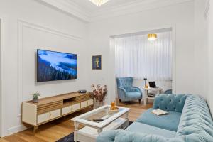 Una sala de estar con un sofá azul y una mesa. en Apartament - Rafinament Arhitectural - Blocul Wilson, en Bucarest