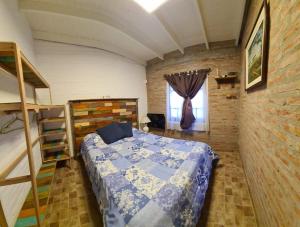 a bedroom with a bed and a brick wall at Rawson casa a minutos del centro y de Playa Unión in Rawson