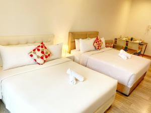 a hotel room with two beds and a couch at LILA SUITES ONE BUKIT CEYLON in Kuala Lumpur