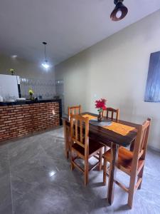 a dining room with a wooden table and chairs at Casa vila costeira. in Camocim