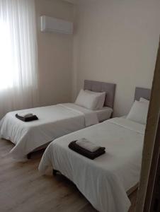 2 Betten in einem Zimmer mit weißen Wänden in der Unterkunft Stadt mitte in Antalya