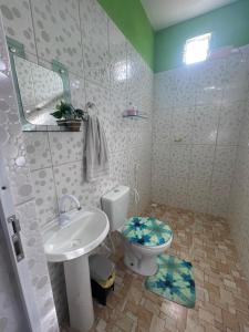a bathroom with a white toilet and a sink at Casa vila costeira. in Camocim