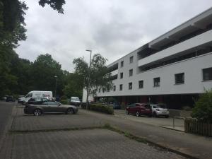 ein Parkplatz mit Autos vor einem Gebäude in der Unterkunft Apartment Hannover Messe in Hannover