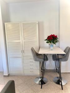 uma mesa e cadeiras com um vaso de flores em Zentrale, neue Wohnung in Bamberg mit kostenlosen Parkplätzen vor Ort em Bamberg