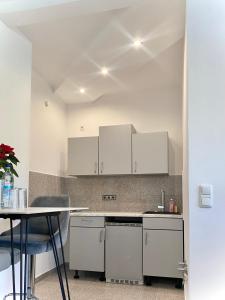 a kitchen with white cabinets and a table at kleines Apartment, nähe Stadtzentrum im 1ten Obergeschoss in Bamberg
