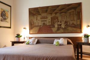 a bedroom with a bed with a painting on the wall at Appartamenti Capenti in Arcidosso