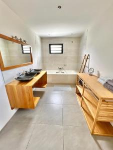 a bathroom with a sink and a bath tub at Villa Moderne et Piscine Privée in Saint-Pierre
