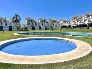 una gran piscina frente a algunos edificios en CASA TRINIDAD, en Huelva