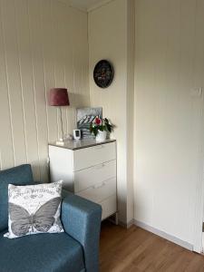 een woonkamer met een blauwe stoel en een lamp bij Guest room in private house in Ålesund