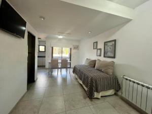 Un dormitorio con una cama y una mesa dentro. en Tres Estrellas y Un Sol Departamentos, en Valeria del Mar