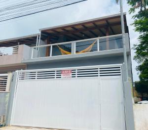 una puerta de garaje blanca con un cartel encima en Casa Barata Próxima a Praia en Bombinhas