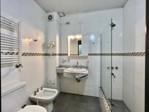 Un baño blanco con inodoro y lavabo. en Tres Estrellas y Un Sol Departamentos, en Valeria del Mar 37 fotos más